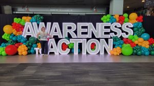 A neon sign that reads "Awareness to Action"
