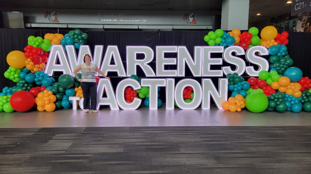 A neon sign that reads "Awareness to Action"